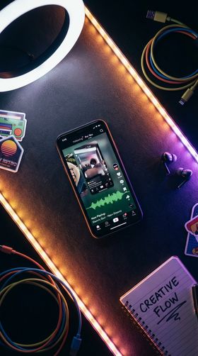 Vibrant music soundwaves and musical notes exploding upward from a smartphone silhouette